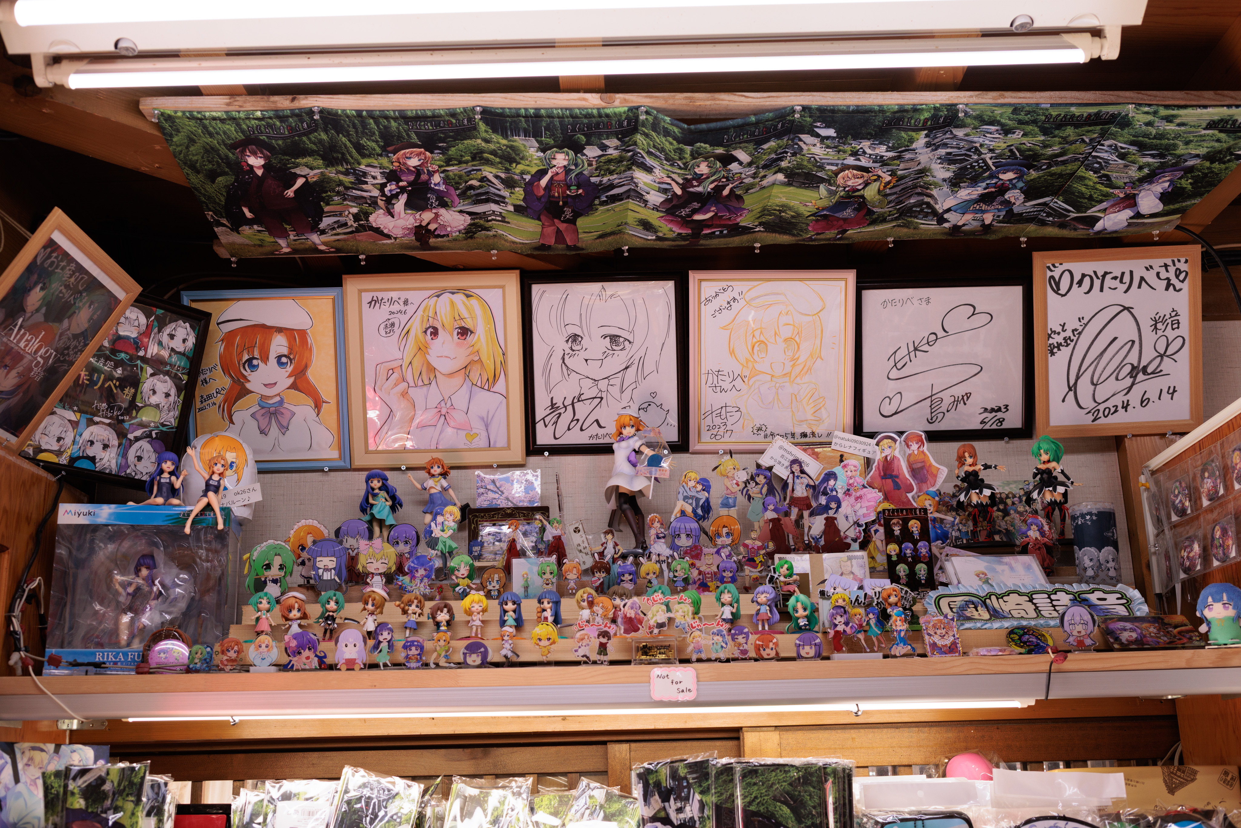 One of the gift shop shrines. Several PVC figures line the shelves and signed artwork is on the wall.